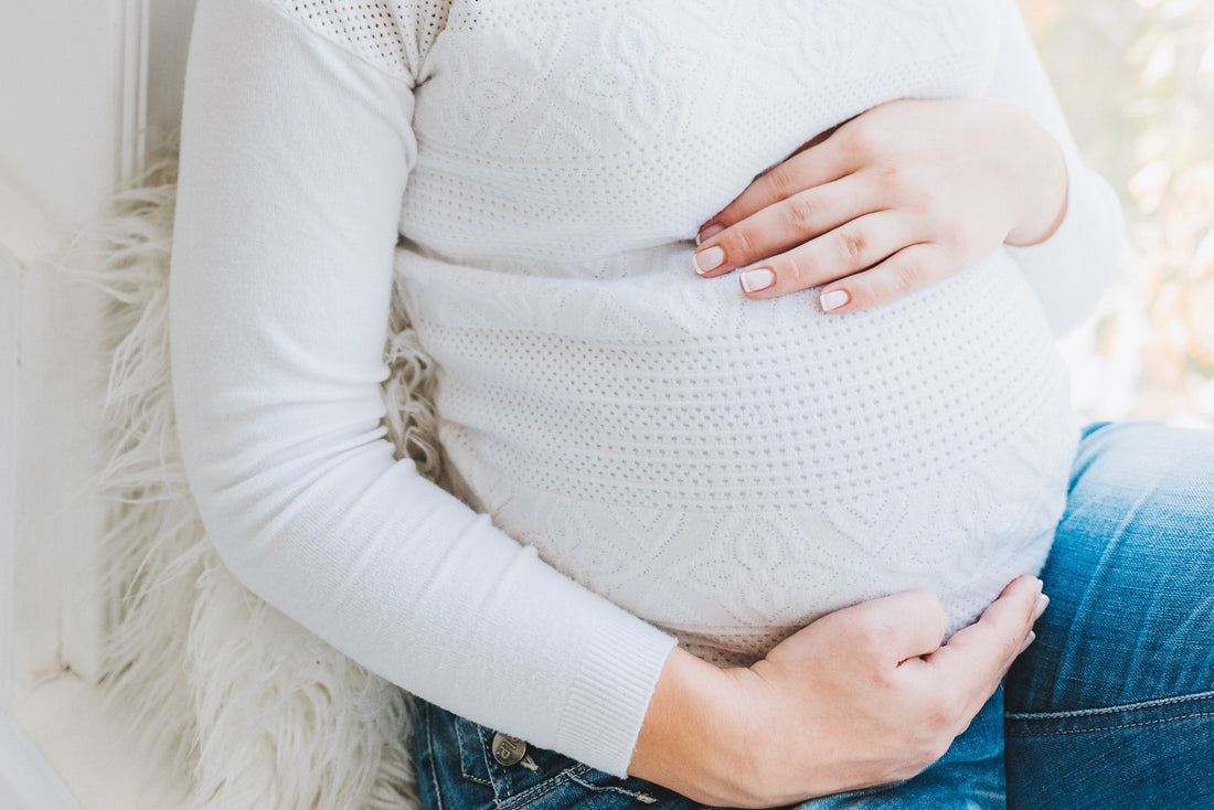Frau hält ihren Schwangerschaftsbauch
